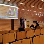 Ponentes con intérprete de lengua de signos y pantalla con el subtitulado